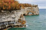 Upper Peninsula Michigan ocean view with cliffs covered in trees on the left side. Image is in full colour.