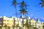 Florida, South Beach. Image of buildings with palm trees in front taken from the ground. Image is in full colour. 