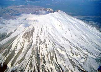 Mt. St. Helens distant shot of a single mountain covered in snow. Image is in full colour 